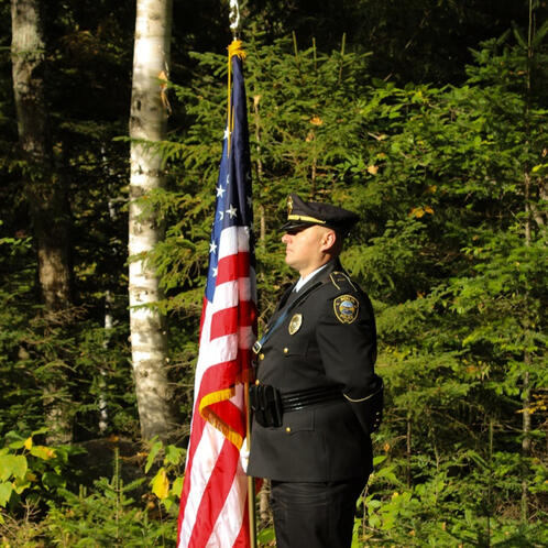 Lt Priest presents the flag at the opening ceremony